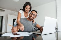 young couple looking at finances on laptop