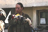 Sgt. Nicole Gee holding a baby at Hamid Karzai International Airport in Kabul
