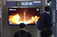 A TV screen shows a report of North Korea's rocket launch with a file image during a news program