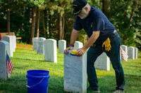 Air Force veteran Tom Lacey joins other volunteers in cleaning headstones during Patriot Day at the Quantico National Cemetery, Triangle, Va.