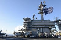 The aircraft carrier USS Theodore Roosevelt flies a replica of Capt. Oliver Hazard Perry’s ‘Don’t Give Up the Ship’ flag as it arrives at Apra Harbor in the Philippine Sea.