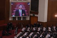 Chinese President Xi Jinping, on screen, listens to the opening remark by Chinese Premier Li Qiang