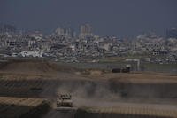 Israeli soldiers move on the top of a tank near the Israeli-Gaza border