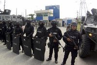 Police stand guard at the entrance of a penitentiary in Guayaquil, Ecuador.