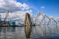 Girders of the Francis Scott Key Bridge stick out of the water around the remaining structural support pier.