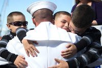 Sailor Embraces his Sons During Homecoming Celebration