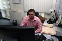Businessman in a pink shirt using a computer.